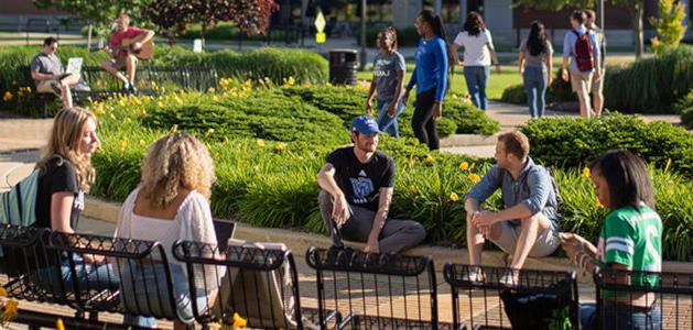 Students gather outside of the entrance to the Student Services Building on Grand Valley State University's Allendale Campus.